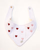 White dog bandana with red and pink heart patterns on a white background