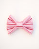 Pink and red striped bow on a white background